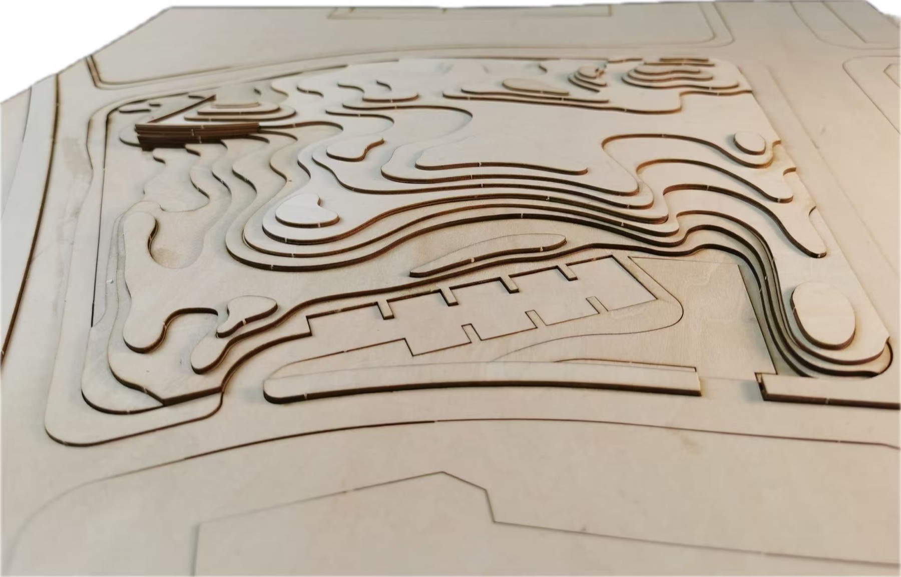 Layered wooden contour model showing landscape topography